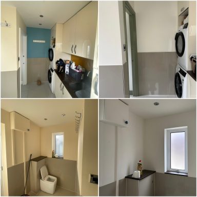 Modern utility room featuring washing machine, grey and white walls, and large windows.